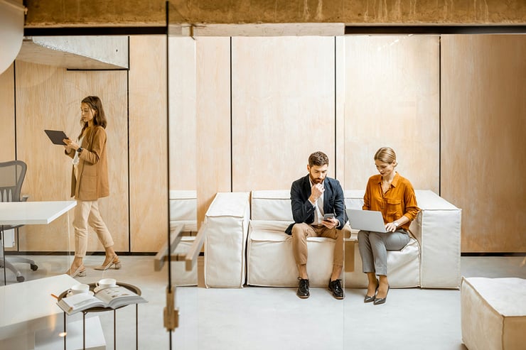 A male and female colleague on the marketing team meet in-person to collaborate on a campaign, using Microsoft Teams to capture in-person note-taking.