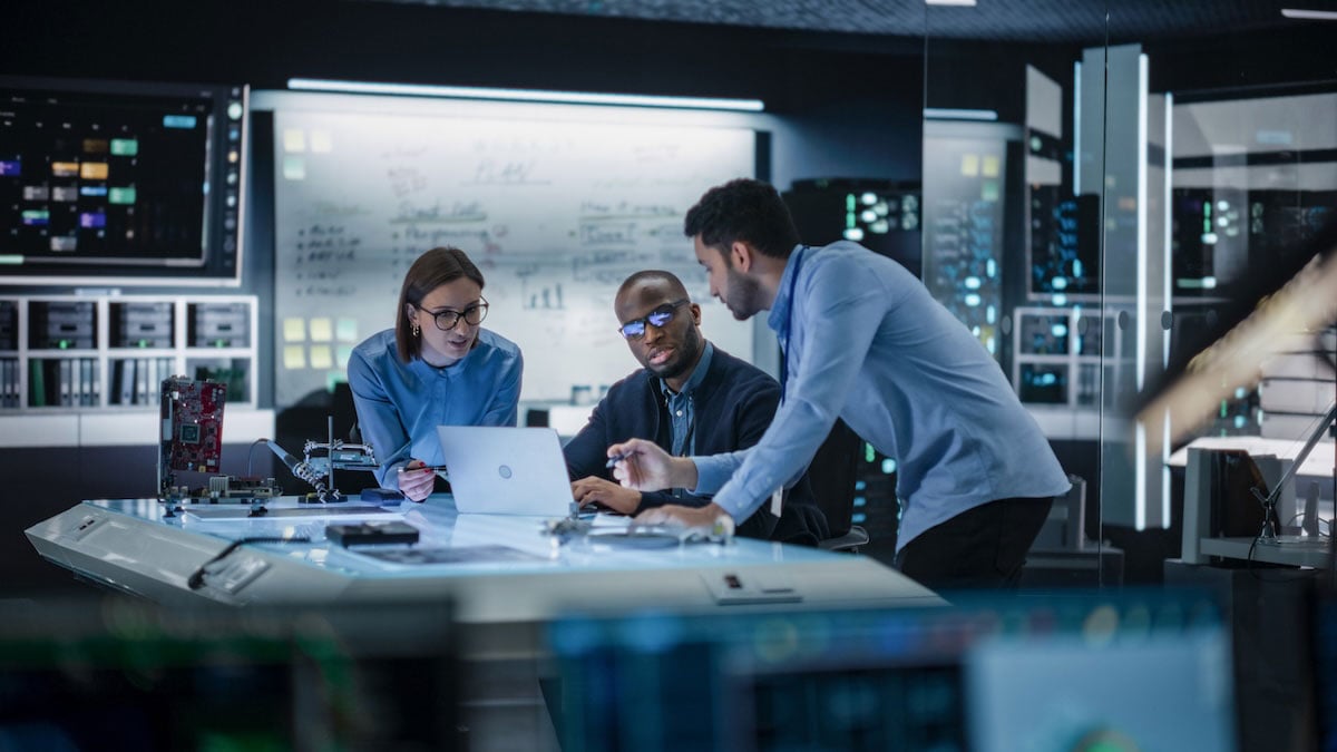 A team of engineers works together on a project, a reminder that early signs of capacity strain can surface in meetings before they become missed deadlines.