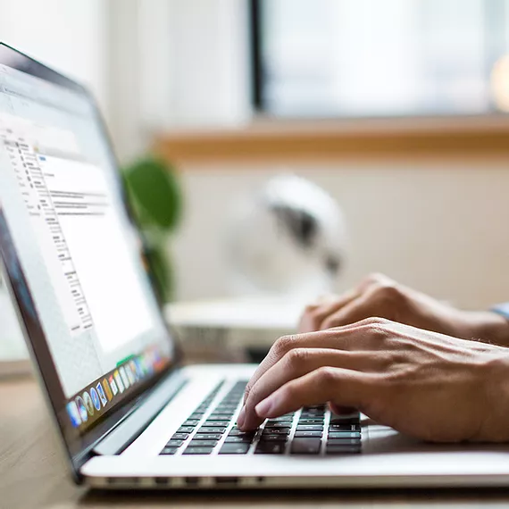 Picture of employee working from home and using laptop to access work email and calendaring in Outlook through Exchange Online