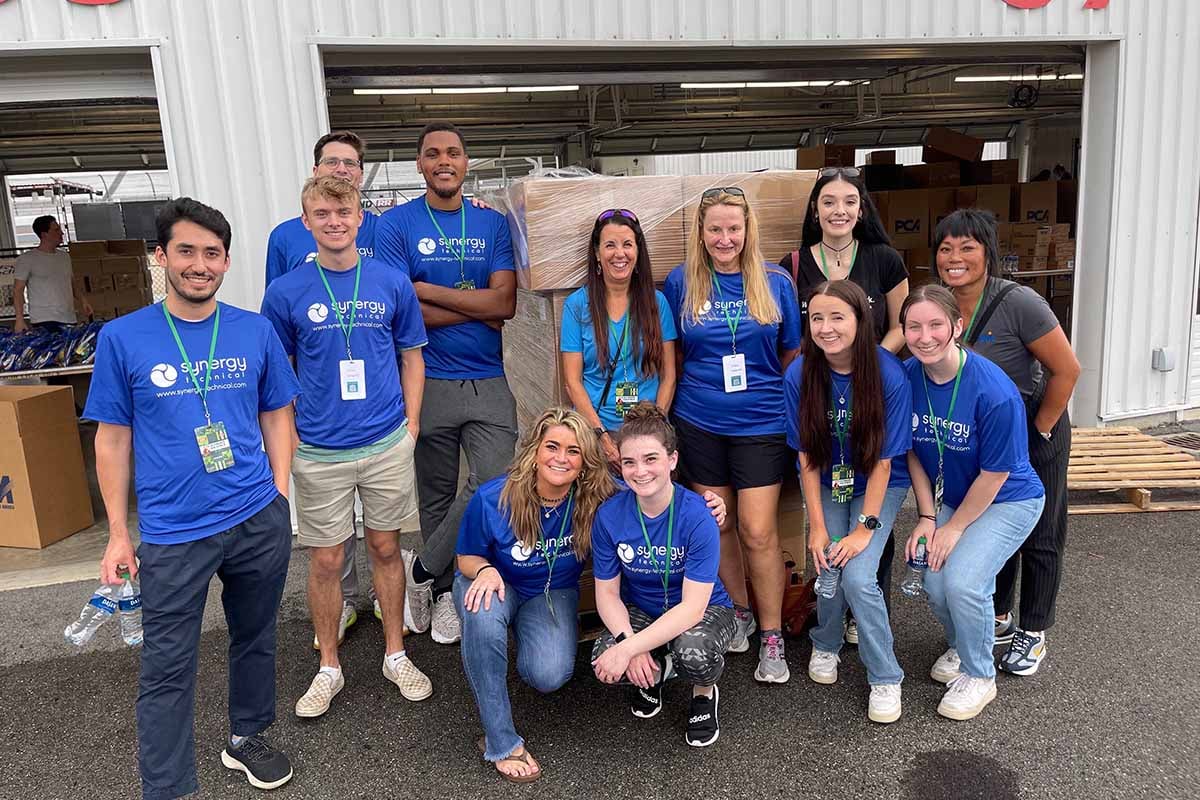 Picture of employees from Synergy Technical volunteering for a Community Outreach event called the Ultimate Backpack Supply Drive where the event aimed to provide underprivileged children with essential school supplies and backpacks filled with educational materials.