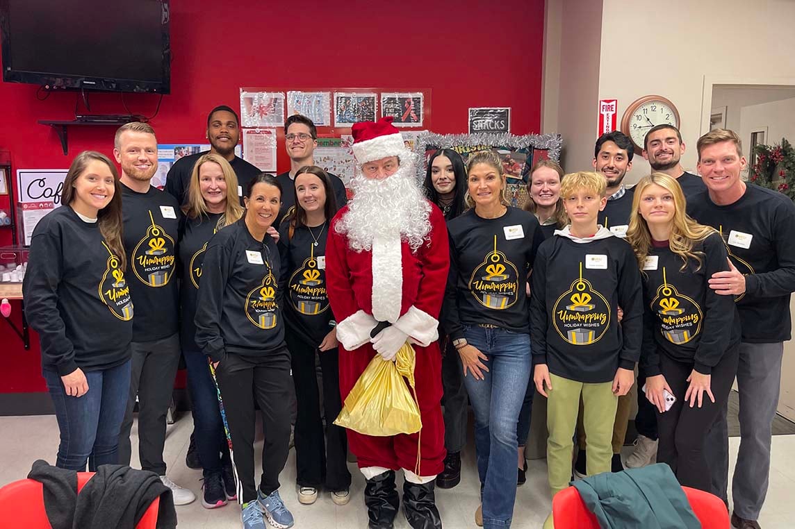 Picture of Synergy Technical team volunteering for an event called Unwrapping Holiday Wishes where volunteers were grouped with one student that their school leaders handpicked, and were able to help the child shop for new clothes and necessities.