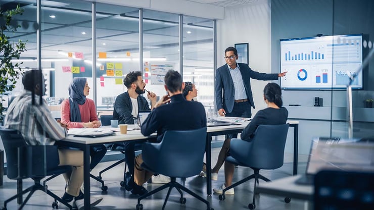 A CFO presents business performance data to company stakeholders, highlighting the importance of linking Microsoft 365 and AI investments to measurable outcomes and ROI.