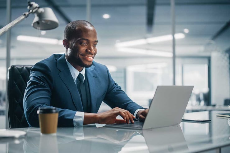 An employee working on a laptop, representing how organizations can align AI initiatives with measurable business outcomes instead of isolated pilot projects.