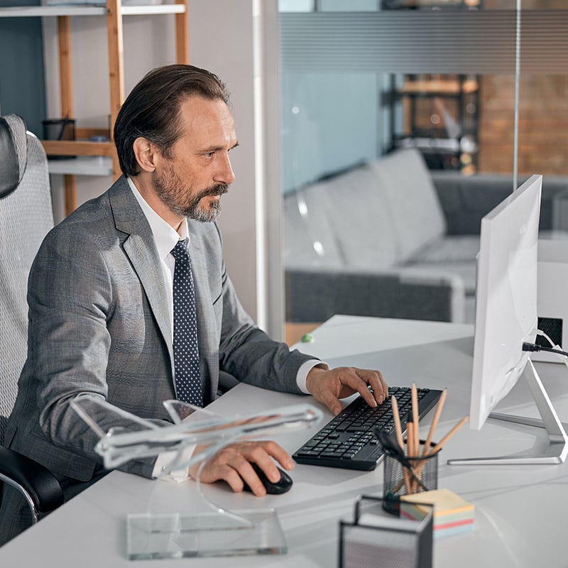 Picture of employee using Microsoft Copilot for Microsoft 365 in Outlook to spend less time on email management by drafting emails, summarizing threads, & catching up on important conversations. 