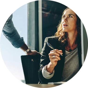 A female IT employee consults with her male counterpart on how Microsoft Intune through Microsoft Enterprise Mobility + Security can help their organization manage devices more efficiently and enforce consistent security policies.