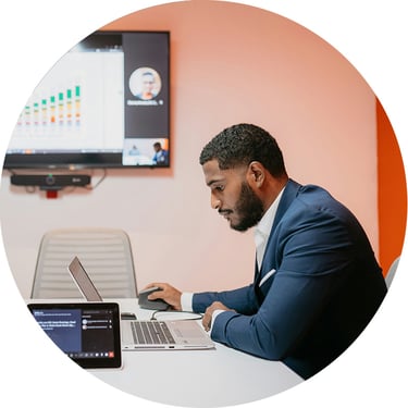 In a meeting room, a male analyst explains complex data that has been consolidated and visualized through Fabric, making it easier for stakeholders to understand performance trends and take meaningful action.