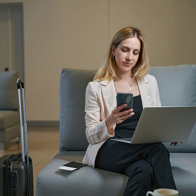 While on a business trip, a female employee securely accesses and edits Word documents through Teams on her mobile device, protected by Microsoft Purview Information Protection.