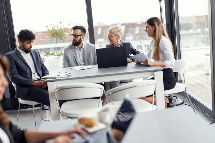 The IT leadership team gathers to review upcoming regulatory changes and uses Microsoft Purview to assess how current policies align with those requirements, leveraging its compliance manager and multicloud visibility to guide next steps.