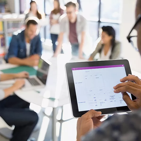An employee sits at a coffee shop, accessing files in OneDrive to edit a presentation, syncing changes in real time to ensure seamless collaboration and finalize the project confidently from anywhere.