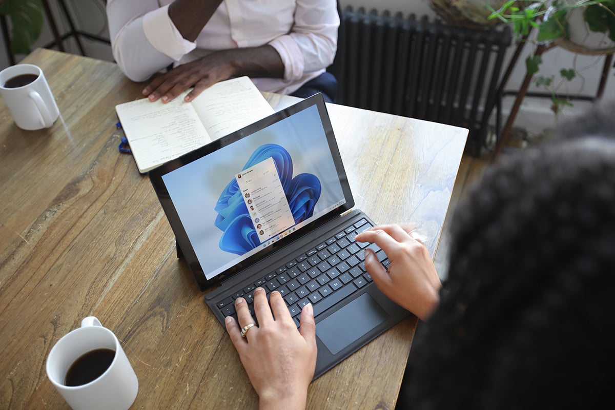 Picture of employee working remotely and is well-trained in using a Windows 11 devices after going through Synergy Technica's Teams Enablement Bootcamp