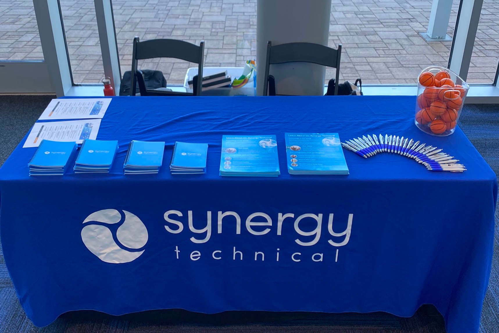 Picture of Synergy Technical booth at GiSTEM event with brochures and swag