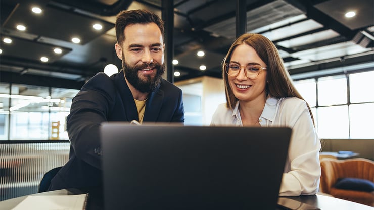 A customer success manager reviews progress with her team leader while using Microsoft Copilot Cowork to support informed business discussions.