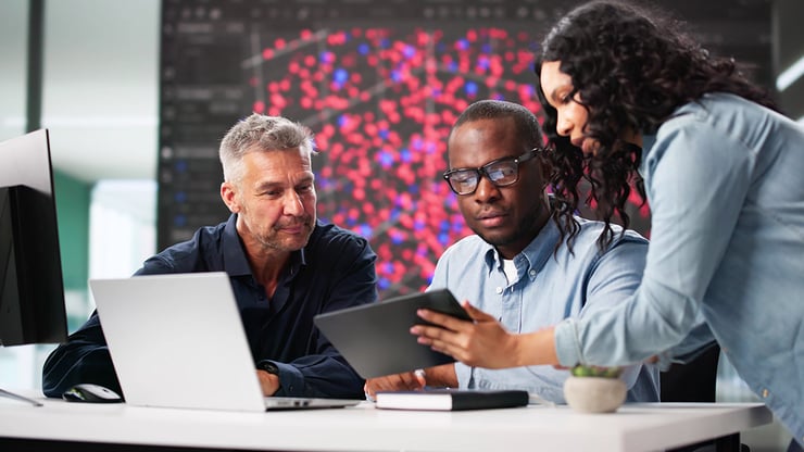 IT professionals review data across laptops, tablets, and desktops while assessing Microsoft Copilot Cowork performance and organizational readiness.