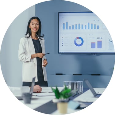 A female executive presents her PowerPoint deck in the meeting room while using Windows 365, which helps keep her desktop experience consistent and available across devices when she needs to stay ready for important meetings.