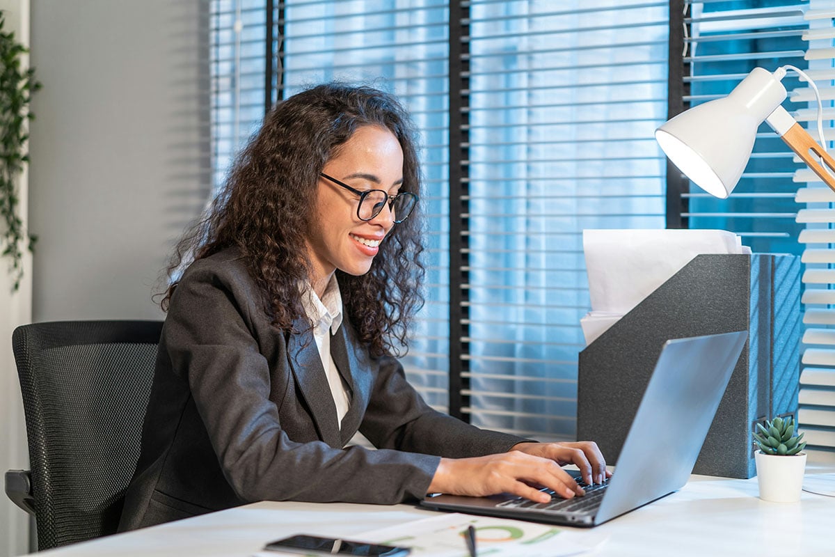 A female analyst at an organization that went through an AI Strategy Enablement holds a tablet in her hand and feels empowered by the broad AI applications she has access to, such as Salesforce AI, to get a lot of work done.