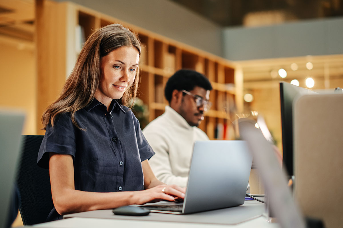 An employee in an organization works on her laptop using AVD.