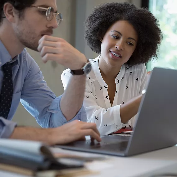 Microsoft Intune enables two employees to collaborate smoothly on a company-provided laptop, ensuring secure access to work files and applications while maintaining compliance with organizational security policies.