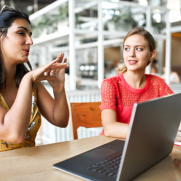 Two female employees meet to plan their next big marketing campaign, with Microsoft Entra Conditional Access ensuring secure access to shared documents and collaboration tools by enforcing identity verification, role-based access controls, and real-time security policies to protect sensitive marketing data.
