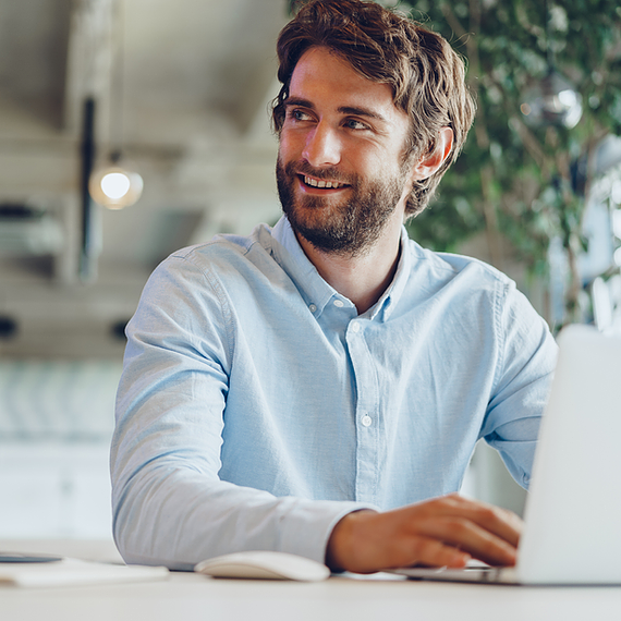 A man uses his laptop with Office 365 malware protection enabled, ensuring his device and email remain secure from malicious attachments and harmful links.