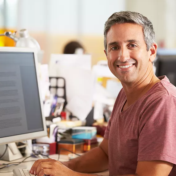An IT manager sits in their office, monitoring a dashboard on their laptop as they use Microsoft 365’s advanced security and device management features, safeguarding employee devices, protecting sensitive data, and ensuring compliance across the organization.