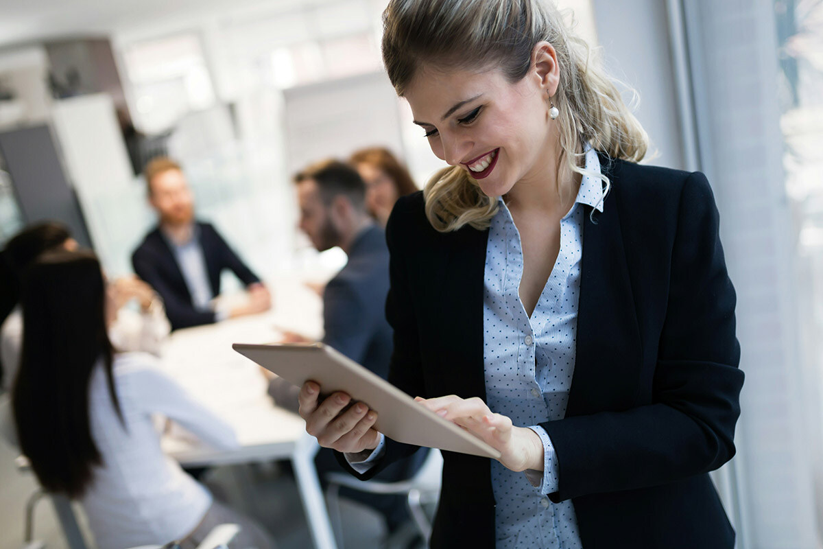 Employee in an accounting firm seen collaborating with one another using devices that are monitored, protected, and supported by Synergy Technical.