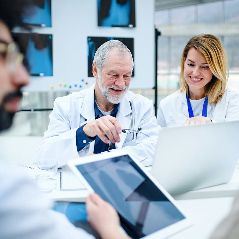 A caregiver in a long-term care facility uses a tablet to track medications, while the MSP safeguards resident data through HIPAA-compliant systems.