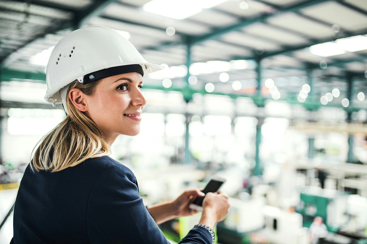An IT employee at her manufacturing firm works on her mobile phone while receiving fast assistance from managed IT services, allowing her to resolve issues quickly and stay productive.