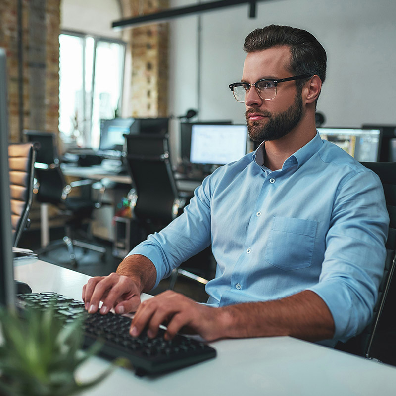 A retail IT employee confidently protects customer trust, backed by managed IT services that proactively defend against cyberattacks and secure critical systems.