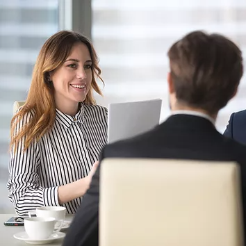 A Synergy Technical managed IT services team member meets with a client in person, reviewing technical diagrams and key challenges, providing hands-on expertise to develop a proactive IT strategy that minimizes limitations and strengthens security.