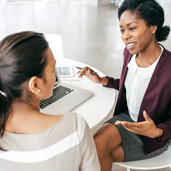 A Synergy Technical managed IT services team member enthusiastically discusses device onboarding with a client, ensuring a seamless setup process, reducing downtime and enabling employees to get to work faster.