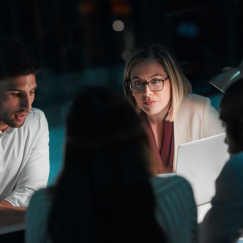A female CIO presents AI agent insights in a C-suite meeting, using Microsoft Agent 365 to show how the organization is scaling AI adoption with stronger governance, security, and accountability.