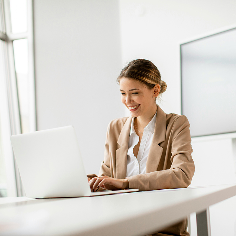 Picture of employee using Copilot for Windows to fine-tune her PC settings and efficiently organize windows with Snap Assist so she can save time and enhance overall work productivity.