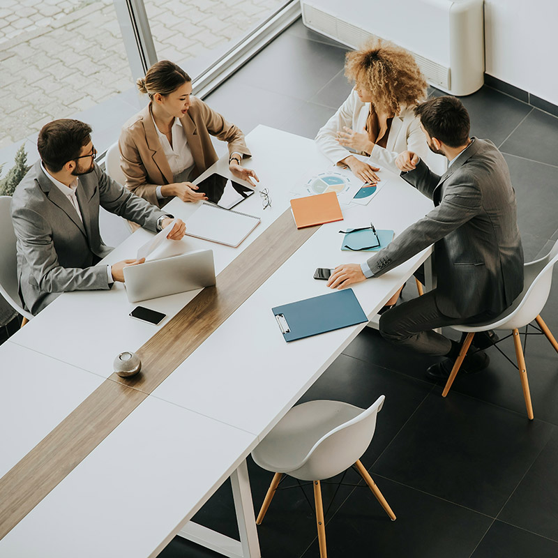 Picture of employee leading a team meeting that is being recorded and transcribed by Copilot to draw out key action items and goals.