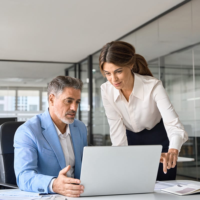 An employee meeting with her colleague benefits from her organization’s use of Microsoft Enterprise Mobility + Security through Defender for Cloud Apps, which helps improve visibility and control across cloud applications.