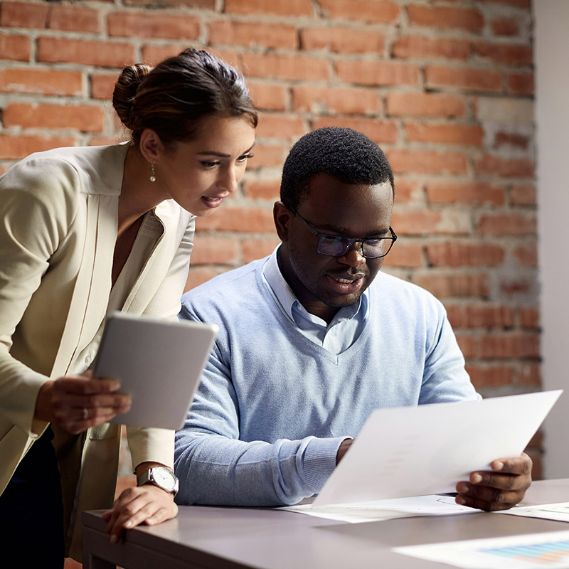 A team in an office collaborates seamlessly, securely accessing critical tools and services through Microsoft Entra ID, which provides single sign-on, adaptive authentication, and automated identity management to streamline workflows and enhance productivity.