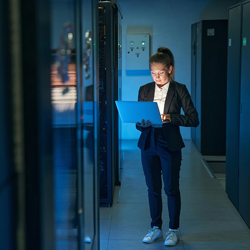A female employee holds her laptop as she types notes into a Word document, with Microsoft Entra Conditional Access ensuring secure collaboration by verifying user identities, enforcing device compliance, and applying adaptive security policies to protect project data in real time.