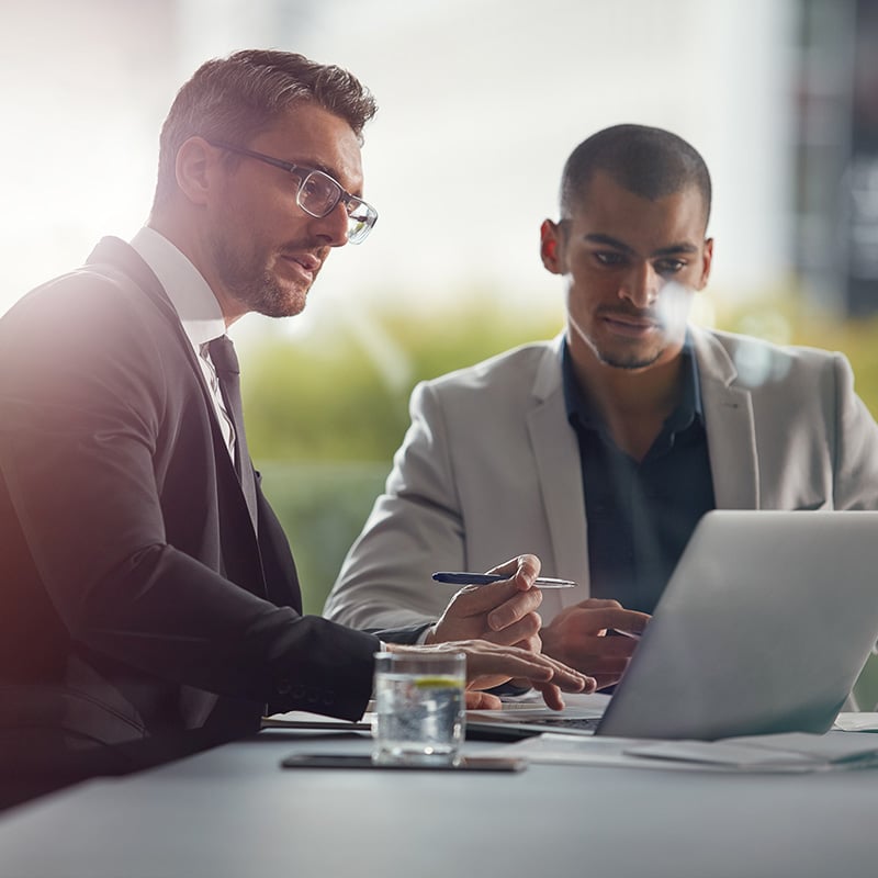 Two VPs scroll through a performance report, noting how a frictionless digital workspace—enabled by Intune EAM—has improved productivity company-wide.