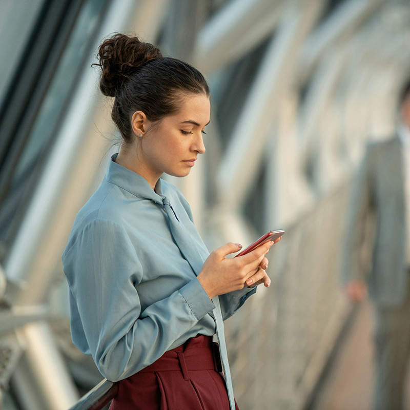 Even while on the go during lunch, a female employee can safely work from her mobile device knowing that her data is governed by Microsoft Purview’s automated retention and deletion policies.