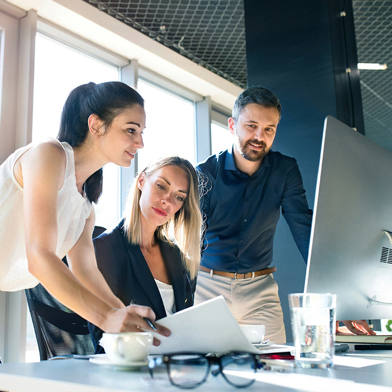 Employees collaborate in Microsoft Teams while Microsoft Purview Data Lifecycle Management enforces background retention policies that ensure messages and shared files are handled securely and compliantly.