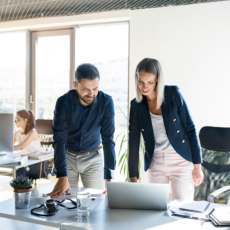 A senior HR employee and a compliance officer examine a laptop screen, reviewing collected files through Purview eDiscovery’s unified platform to make quick decisions during a sensitive case.