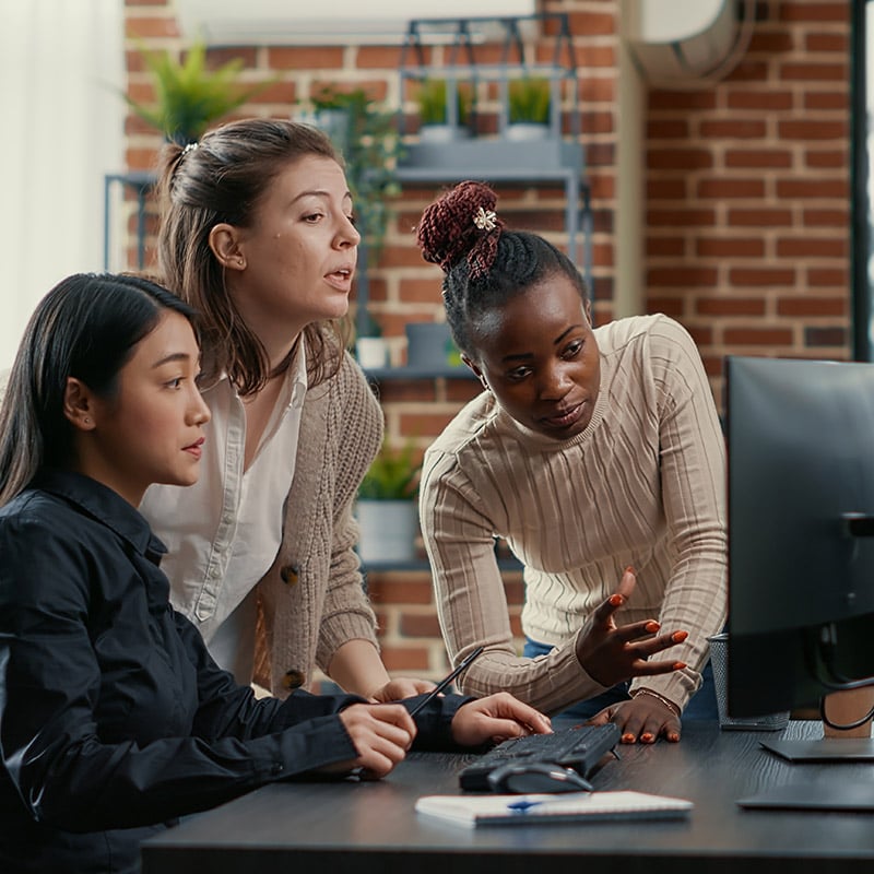 A group of SOC analysts collaborate around a workstation while using Microsoft Security Copilot insights to investigate threats faster and coordinate their response strategy.