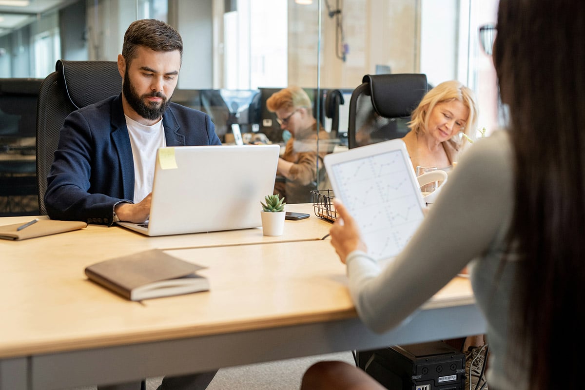An IT consultant from Synergy Technical leads a collaborative discussion with a client, asking targeted questions to assess their environment for BCDR readiness.
