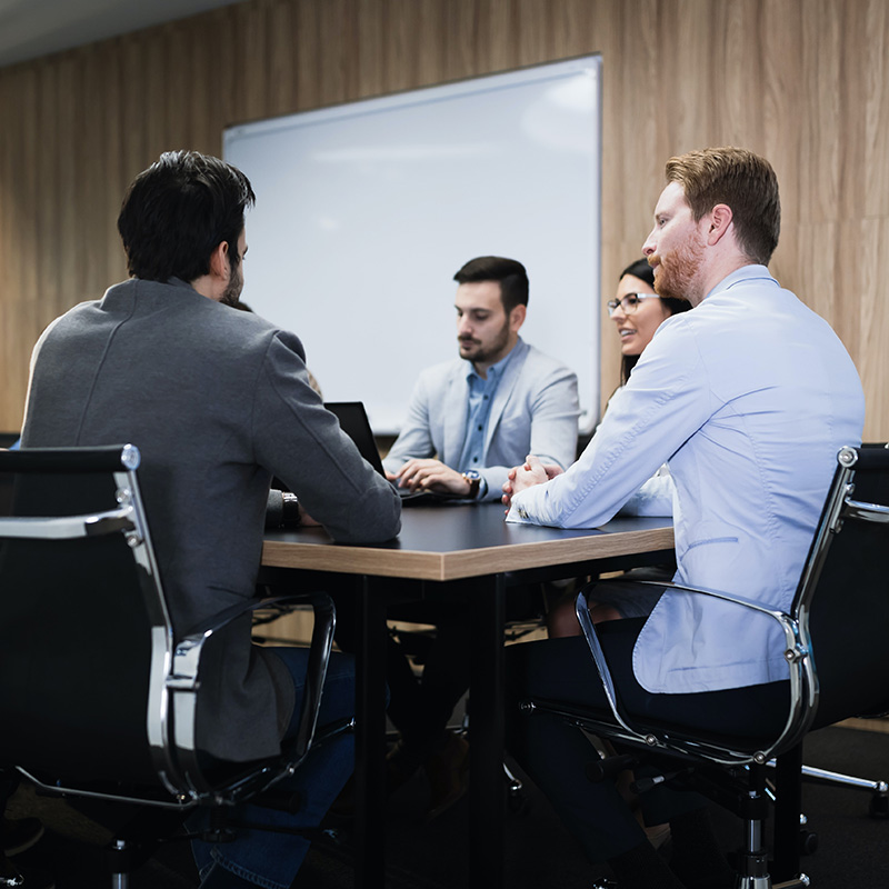 Picture of a team meeting, discussing upcoming project to explore using Power Apps to construct low-code, no-code custom business apps for enhanced efficiency