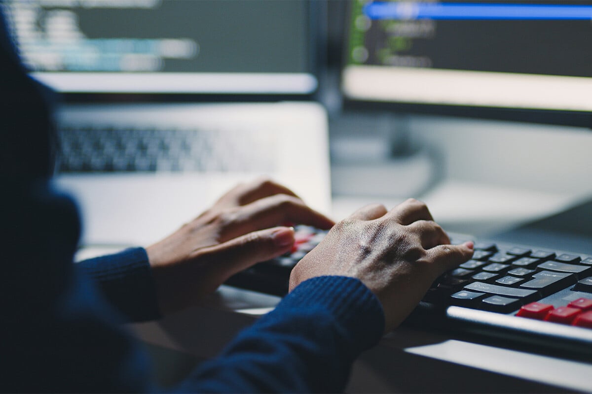 A male IT security engineer uses a SIEM tool implemented after Synergy Technical helped build a roadmap for the organization to efficiently and securely monitor potential threats.