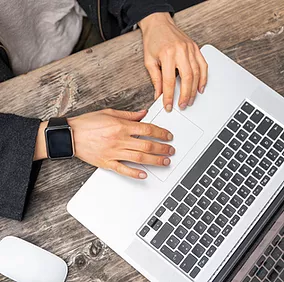 An employee types on her laptop while seamlessly authenticating her identity with Microsoft Entra Multifactor Authentication, benefiting from a streamlined, secure login process that balances security with user convenience.