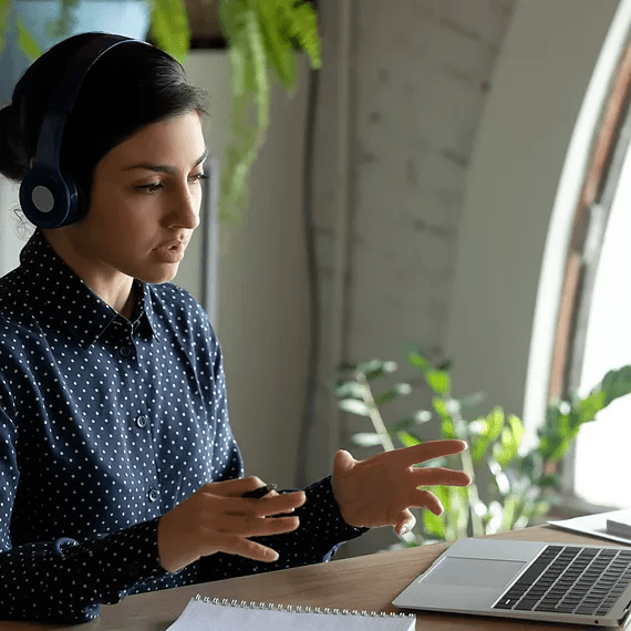 A female employee at an accounting firm facilitates a webinar, engaging with attendees as she presents key financial insights, with the session recorded and later available on Microsoft Stream for on-demand viewing and team collaboration.