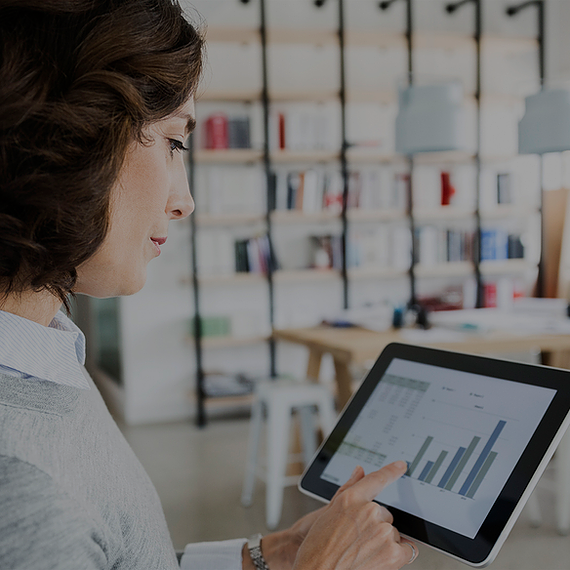 A female employee in an office analyzes data on her Surface tablet using Excel, with Microsoft Entra conditional access ensuring secure access by enforcing role-based controls, verifying device compliance, and applying real-time risk assessments to protect sensitive business data.