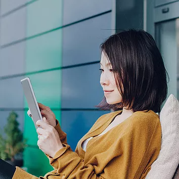 A woman accessing corporate data securely on her mobile device outside the corporate perimeter