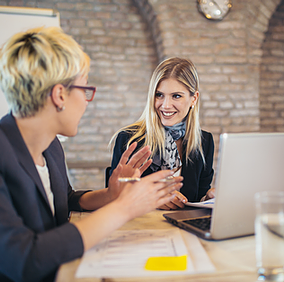 A team of analysts at an accounting firm, including two female employees with their laptops open, collaborate in Microsoft Teams, brainstorming ideas and capturing notes in real time to drive their project forward efficiently.